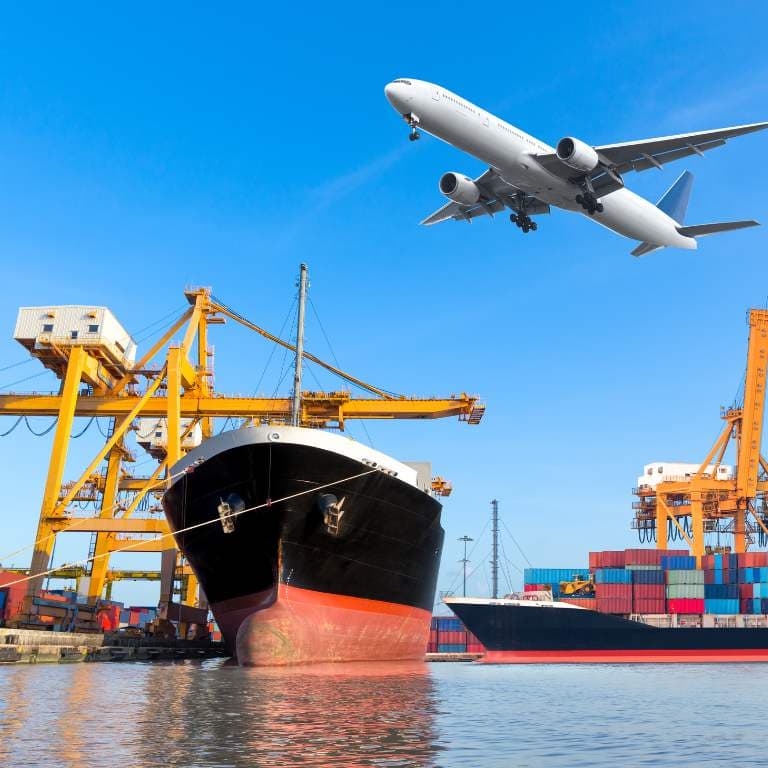 A cargo plane over a container ship being loaded at port